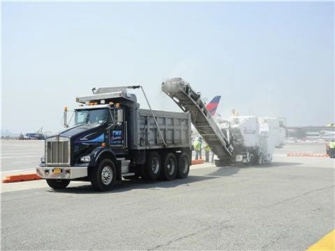 Professional contractor applying asphalt for a new driveway by Romano Paving, showcasing expertise in paving and concrete services.